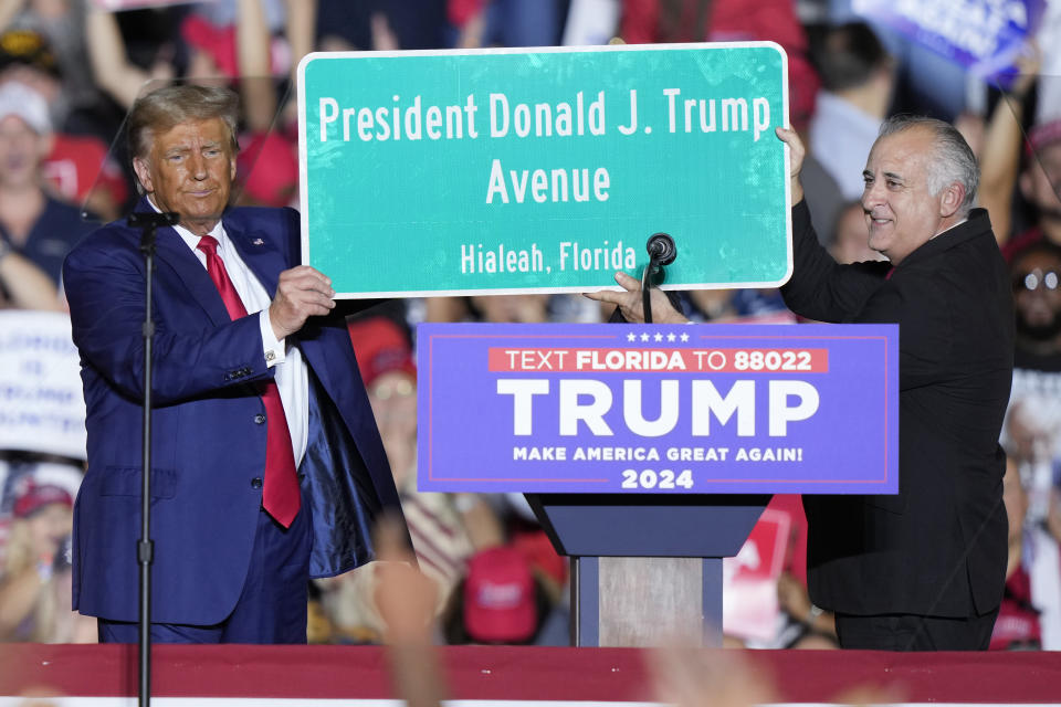 Former President Donald Trump holds a sign with Hialeah Mayor Esteban Bovo at a campaign rally in Hialeah, Fla., Wednesday, Nov. 8, 2023. (AP Photo/Lynne Sladky)