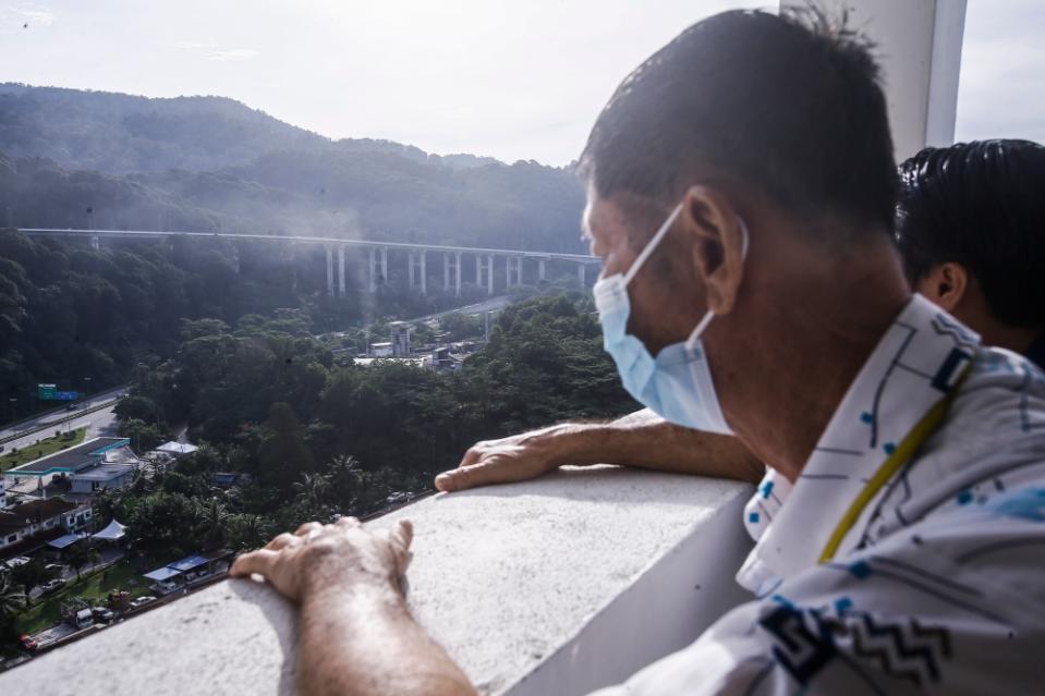 Legendview condo management secretary Syee Chong Wah shows how close his block is to the adjacent factory in Rawang, Selangor. May 20, 2023. — Picture by Hari Anggara