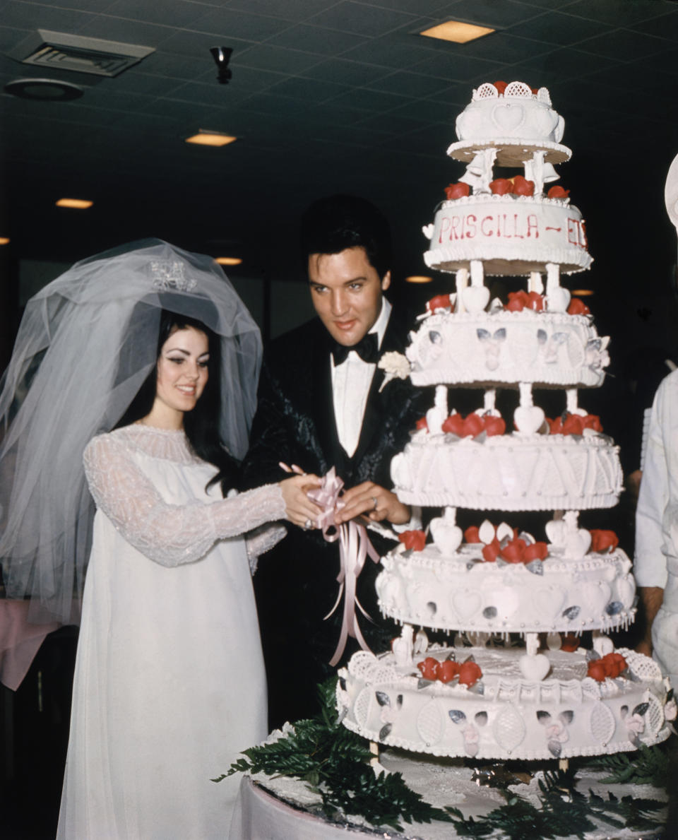 Elvis and Priscilla Presley Cutting Wedding Cake (Bettmann Archive)