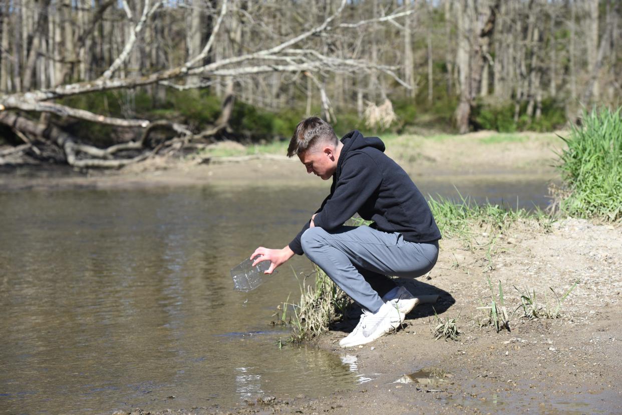 Marysville High School senior Kyle Beecherl, 17, releasing a salmon into the Belle River at Columbus County Park on April 26, 2024.