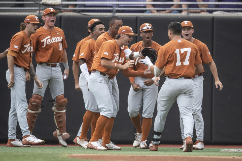 Texas' Ivan Melendez is met by his teammates after hitting a home run during the first inning of an NCAA college super regional baseball game against East Carolina on Sunday, June 12, 2022, in Greenville, N.C. (AP Photo/Matt Kelley)