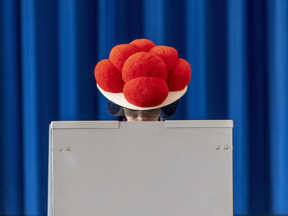 A woman with a tradtional hat casts her vote for the European elections in the black forest city of Gutach, southern Germany, Sunday, May 26, 2019. (Patrick Seeger/dpa via AP)