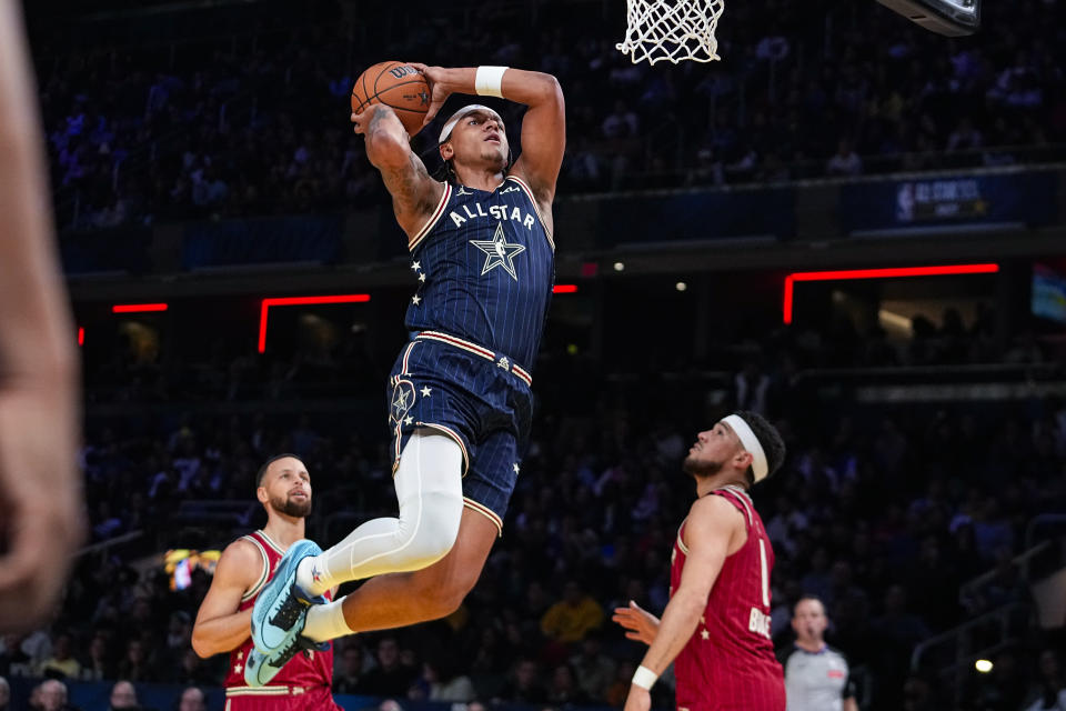 Orlando Magic forward Paolo Banchero (5) goes up for a dunk over Phoenix Suns guard Devin Booker (1) during the second half of an NBA All-Star basketball game in Indianapolis, Sunday, Feb. 18, 2024. (AP Photo/Darron Cummings)