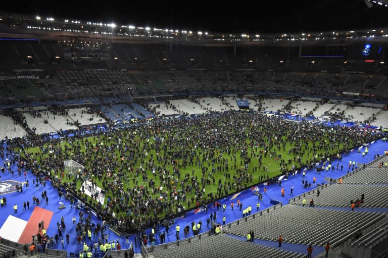 Spectators gather on the pitch after an explosion outside the Stade de France stadium in November 2015