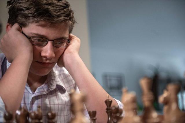 The little boy ponders the next chess move. Stock Photo