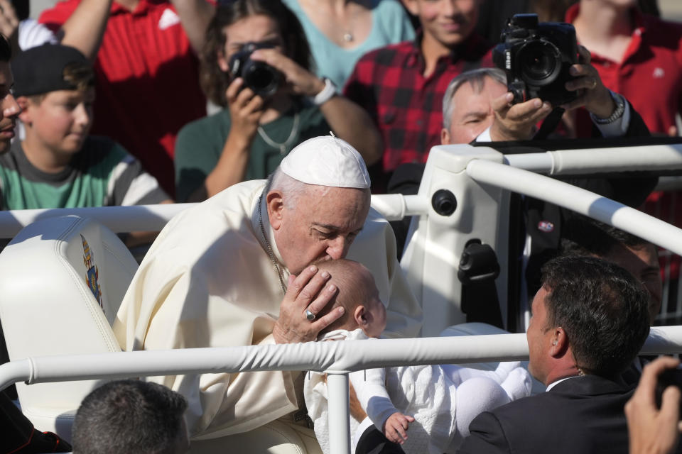 Pope Francis kisses a child as he arrives at the National Shrine of Saint Anne de Beaupré to celebrate mass, in Quebec City, Canada, Thursday, July 28, 2022. Pope Francis crisscrossed Canada this week delivering long overdue apologies to the country's Indigenous groups for the decades of abuses and cultural destruction they suffered at Catholic Church-run residential schools. (AP Photo/Gregorio Borgia)