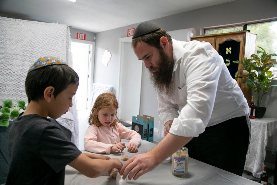 Rabbi Shlomo Levertov and his children fill small plastic containers of Maror for the Seder 2 Go kits at their home on March 25, 2021.
