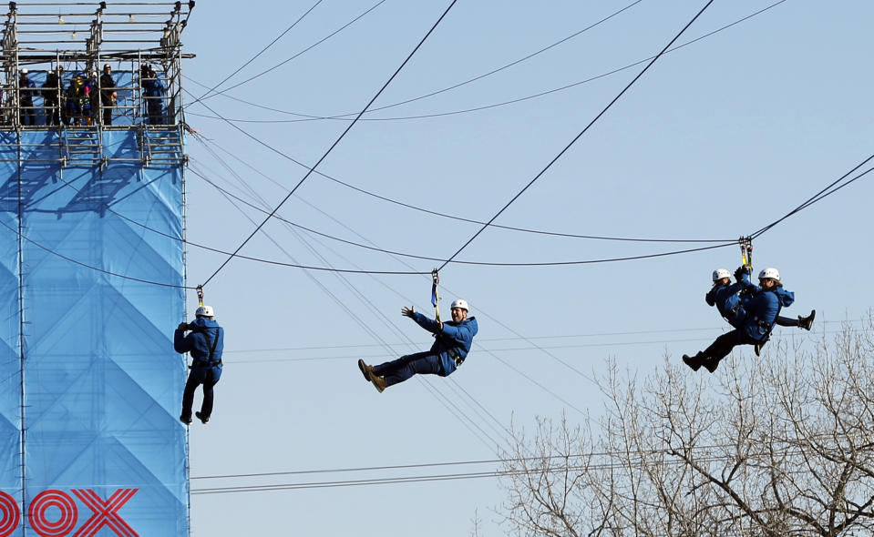 Zipline enthusiasts including politicians, celebrities and media cross the Mississippi River in Minneapolis Friday, Jan. 26, 2018 as the 10-day Bold North theme festival got underway, one of many events leading up to the Super Bowl. (AP Photo/Jim Mone)