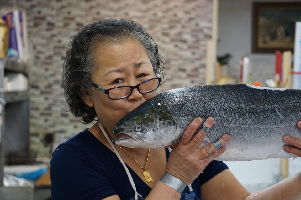 Owner Sun Thompson kissing a salmon at Chang's Fish Market, 110 Johnson St., Fayetteville.