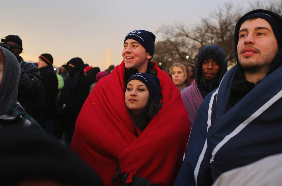 Brandon Adamski and Alicia Burke keep warm in a blanket as they and others gather near the U.S. Capitol building on the National Mall for the Inauguration ceremony on January 21, 2013 in Washington, DC. U.S. President Barack Obama, will be ceremonially sworn in for his second term today. (Photo by Joe Raedle/Getty Images)