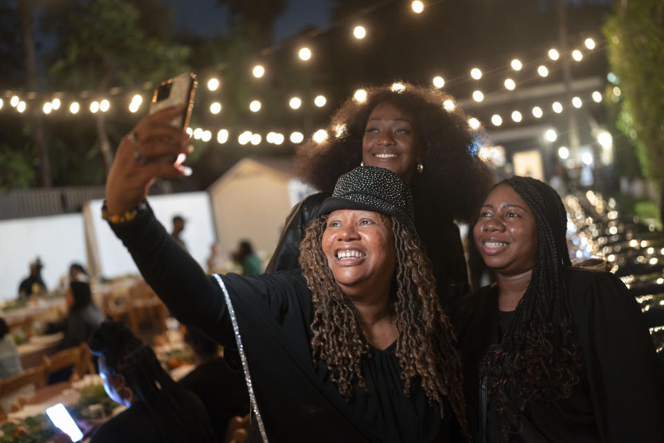 Beatrice X Johnson, center, who is also known as Auntie Bee, Denica Davis, top, and Lashawnda Rhymes take a selfie during a welcome dinner for the annual Families United 4 Justice Network Conference, hosted by the Black Lives Matter Global Network Foundation at its mansion in the Studio City neighborhood of Los Angeles, Thursday, Sept. 28, 2023. (AP Photo/Jae C. Hong)