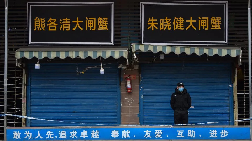 A security guard stands outside a wet market in Wuhan linked to some of the earliest known cases of Covid-19. - Hector Retamal/AFP/Getty Images