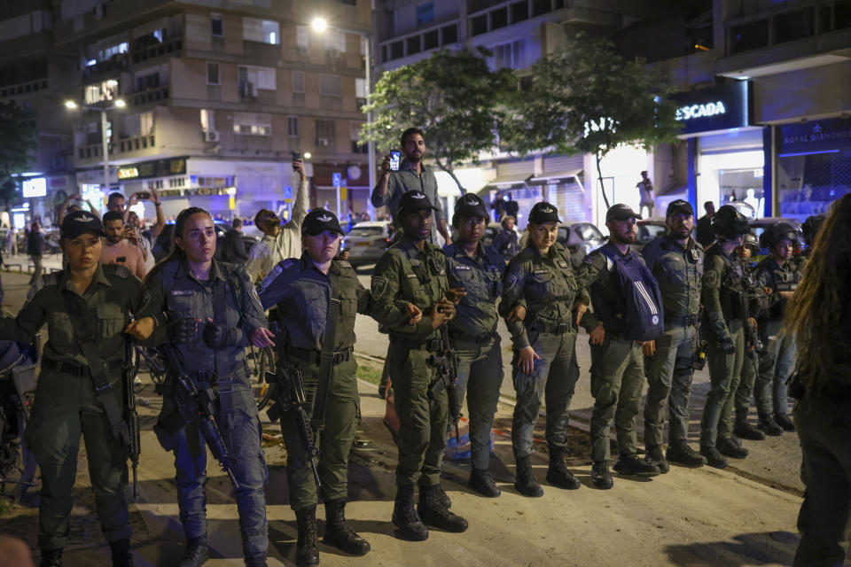 Police stand guard outside a Tel Aviv salon where protesters demonstrating against the government's planned judicial overhaul amassed on Wednesday, March 1, 2023, after learning that the prime minister's wife, Sara Netanyahu, was getting her hair done inside. Sara Netanyahu has long been a polarizing figure in Israel, and the salon siege reflected the country's emotionally charged divide over the overhaul. (AP Photo/Oren Ziv)