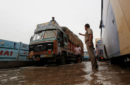 A policeman directs the vehicles in a waterlogged highway after heavy rains in Gurugram, previously known as Gurgaon, on the outskirts of New Delhi, India, July 29, 2016. REUTERS/Adnan Abidi