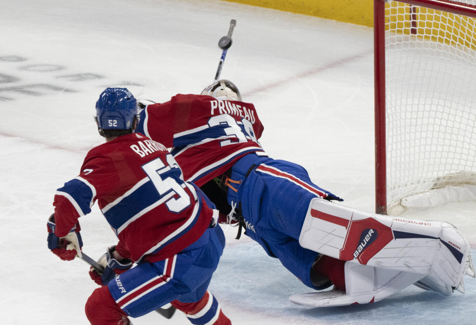 Montreal Canadiens goaltender Cayden Primeau (30) makes a diving save against the New Jersey Devils as Justin Barron (52) skates watches during the first period of an NHL hockey game Tuesday, Oct. 24. 2023, in Montreal. (Christinne Muschi/The Canadian Press via AP)