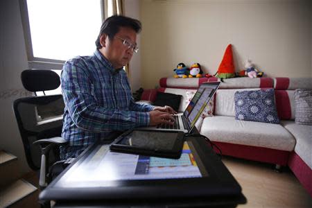 Chinese cartoonist Wang Liming uses his computer inside his apartment before an interview with Reuters in Beijing, Ocotober 22, 2013. REUTERS/Petar Kujundzic