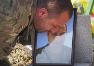 A man says goodbye during a funeral of his comrade at a cemetery in Stepanakert, the separatist region of Nagorno-Karabakh, Friday, Oct. 30, 2020. The Azerbaijani army has closed in on a key town in the separatist territory of Nagorno-Karabakh following more than a month of intense fighting. (AP Photo)