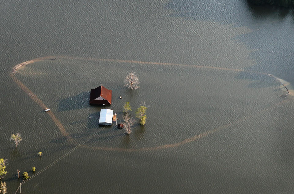 VICKSBURG, MS - MAY 18: Floodwater from the Yazoo River flows over a levee surrounding a farm May 18, 2011 near Vicksburg, Mississippi. The flooded Mississippi River is forcing the Yazoo River to top its banks where the two meet near Vicksburg, causing towns and farms upstream on the Yazoo to flood. The Mississippi River at Vicksburg is expected to crest May 19. Heavy rains have left the ground saturated, rivers swollen, and have caused widespread flooding along the Mississippi River from Illinois to Louisiana. (Photo by Scott Olson/Getty Images)