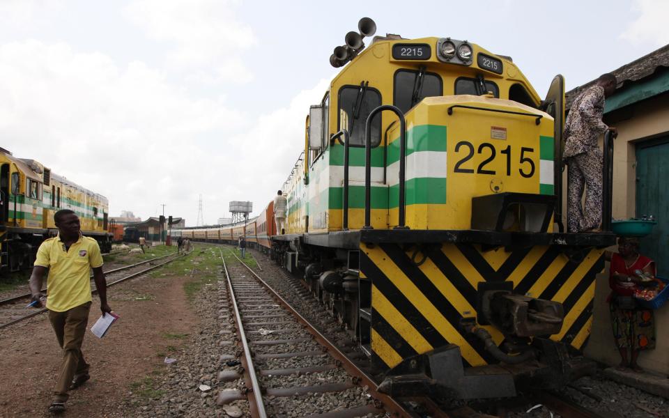 In this Photo taken, Friday, March . 8, 2013, A man walks past an Ooni of Ife train to Kano, at a terminal in Lagos, Nigeria. Nigeria reopened its train line to the north Dec. 21, marking the end of a $166 million project to rebuild portions of the abandoned line washed out years earlier. The state-owned China Civil Engineering Construction Corp. rebuilt the southern portion of the line, while a Nigerian company handled the rest. ( AP Photo/Sunday Alamba)