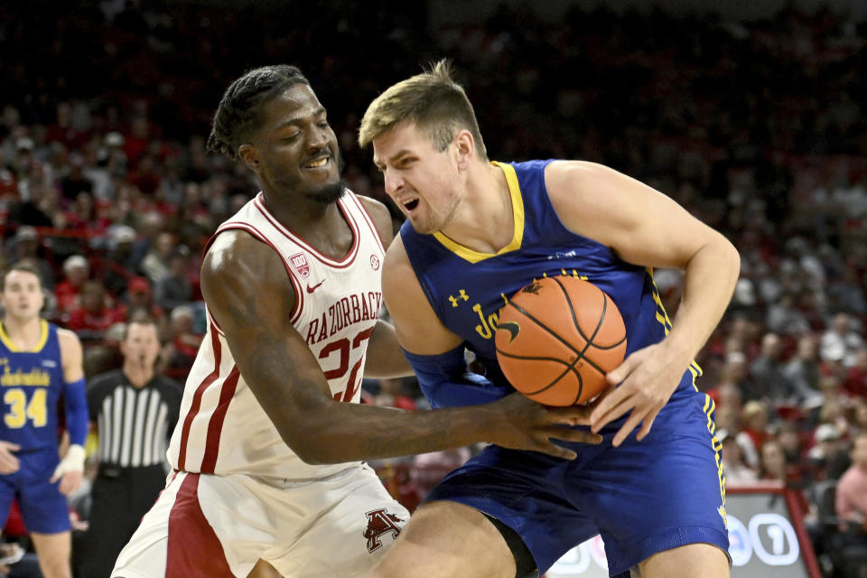 Arkansas forward Makhel Mitchell (22) knocks the ball away from South Dakota State forward Luke Appel (13) as he drives to the basket during the first half of an NCAA college basketball game Wednesday, Nov. 16, 2022, in Fayetteville, Ark. (AP Photo/Michael Woods)