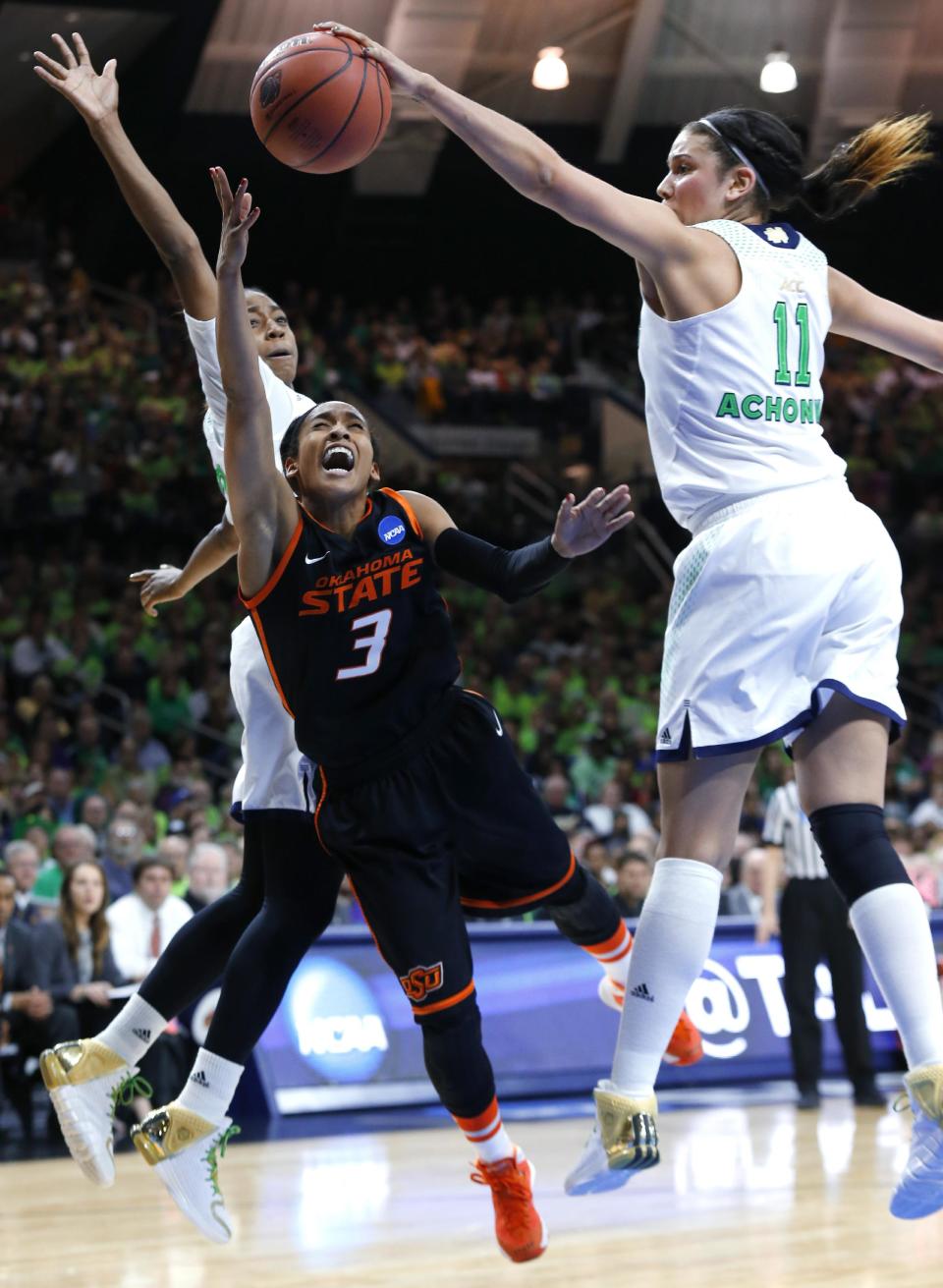 Notre Dame forward Natalie Achonwa (11) blocks a shot by Oklahoma State guard Tiffany Bias (3) as guard Jewell Loyd, at rear, helps to defend during the second half of a regional semifinal in the NCAA college basketball tournament at the Purcell Pavilion in South Bend, Ind., Saturday, March 29, 2014. (AP Photo/Paul Sancya)