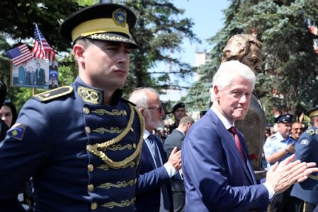 Former U.S. President Bill Clinton applauds during the inauguration of the monument of Madeleine Albright at the 20th anniversary of the Deployment of NATO Troops in Kosovo in Pristina