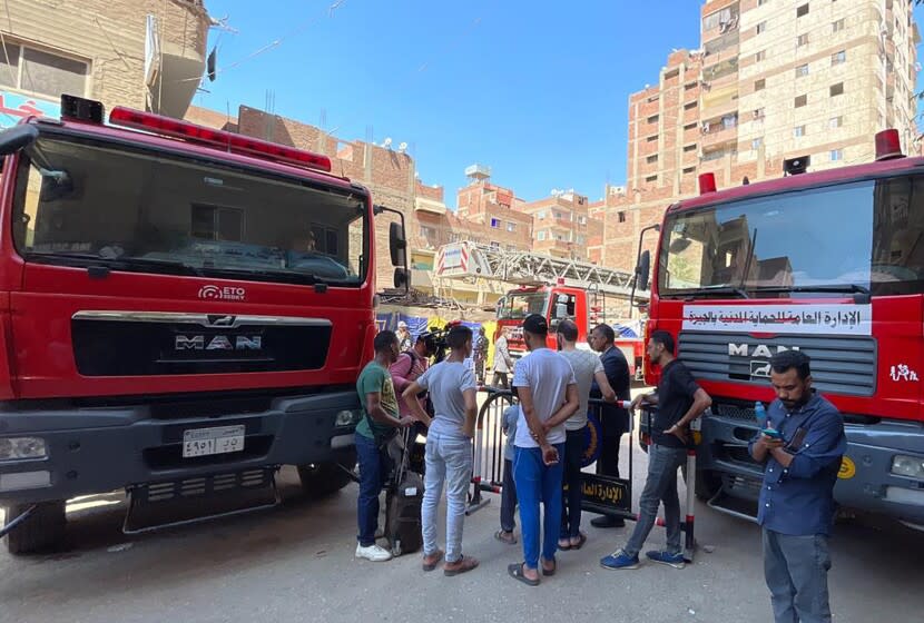 People gather near the Abu Sefein church in Cairo as emergency personnel respond to a fire on Sunday.