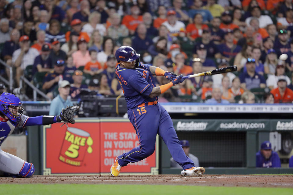 Houston Astros' Martin Maldonado (15) connects for a one-run RBI-single in front of Texas Rangers catcher Jonah Heim, left, during the second inning of a baseball game Monday, Sept. 5, 2022, in Houston. (AP Photo/Michael Wyke)