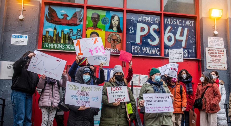 Teachers protest with signs calling for increased COVID-19 testing in New York City schools.