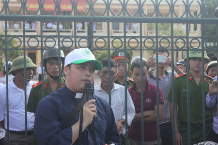 Catholic Priest Anthony Dang Huu Nam talks with Vietnamese fishermen who wait outside the people's court as they prepare to sue Formosa Ha Tinh Steel, a subsidiary of Taiwan's Formosa Plastics, over an accident at one of its steel plant which caused massive fish deaths along a 200-km (120-mile) stretch of coastline, in Vietnam's central province of Ha Tinh, September 26, 2016. Handout via