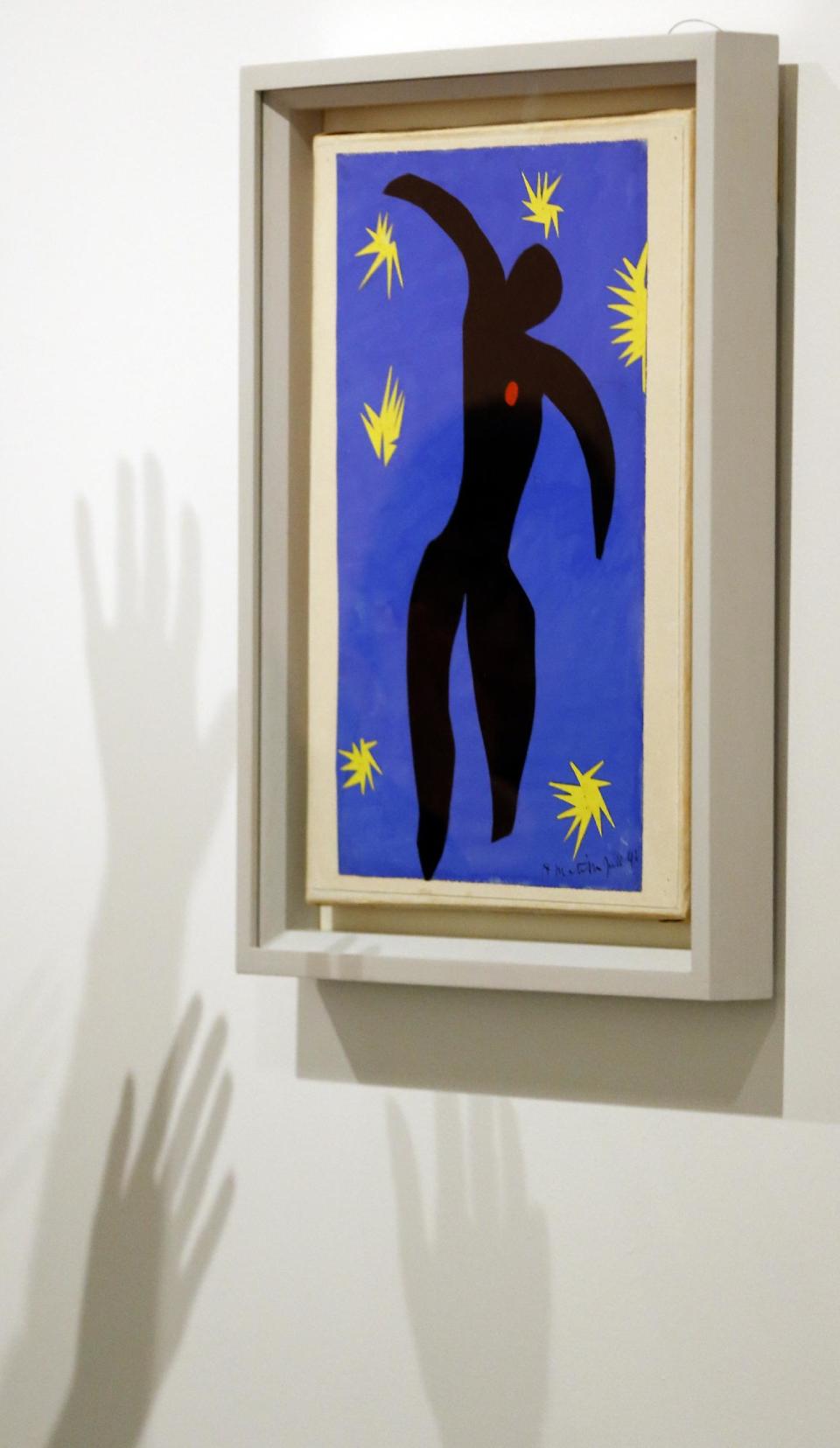 Shadows are cast by peoples hands on a wall alongside 'Icarus' by Henri Matisse, on display during a media opportunity at The Tate Modern in London, Monday, April 14, 2014. The artworks are part of the 'Henri Matisse: The Cut-Outs' exhibition that runs at the gallery from April 17 until Sept. 7, 2014.(AP Photo/Kirsty Wigglesworth)