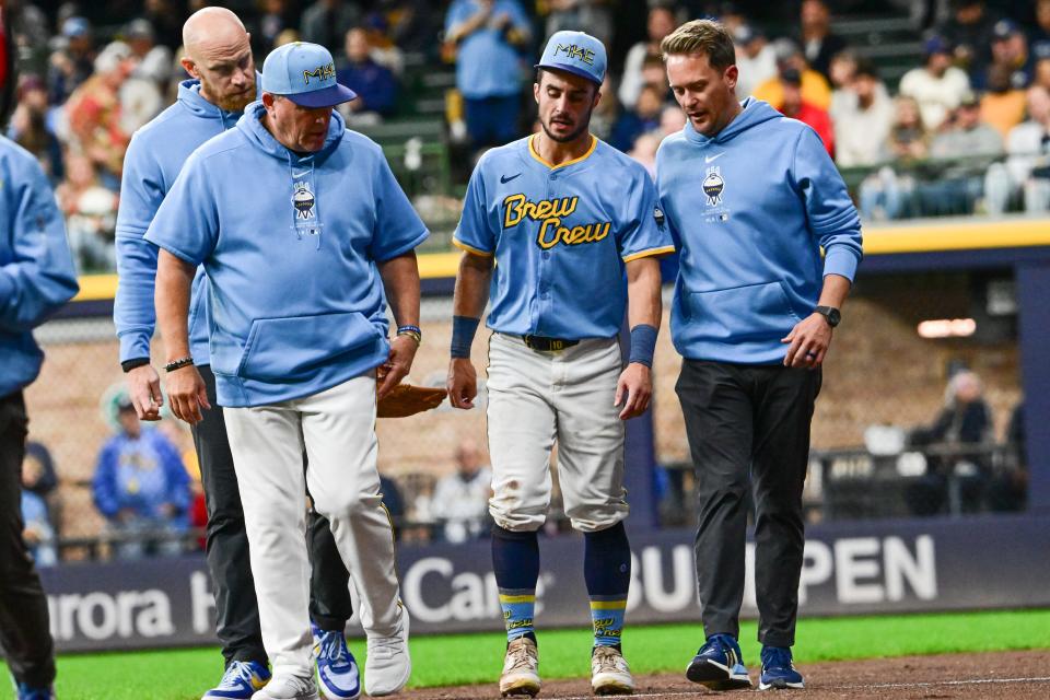 Brewers rightfielder Sal Frelick walks off the field with an apparent injury after crashing into the wall attempting to make a catch in the third inning against the Mets on Friday night at American Family Field.