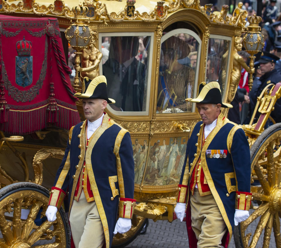 In this Tuesday, Sept. 17, 2013, file image, Netherlands' King Willem-Alexander and his wife Queen Maxima arrive in the Golden Carriage at Noordeinde Palace, after the King officially opened the new parliamentary year in The Hague, Netherlands. Even the horse-drawn Golden Carriage, currently undergoing a lengthy restoration but traditionally used to carry the Dutch monarch to the state opening of Parliament each year, has drawn criticism because one of its panels, center, is decorated with a painting depicting Africans and Asians carrying goods to present to their colonial masters. (AP Photo/Peter Dejong, file)