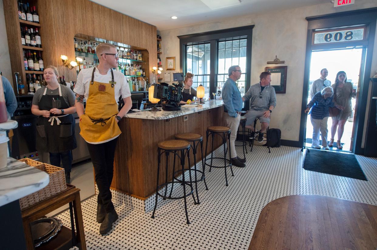 Elvie's chef and owner Hunter Evans, second from left, looks toward the door of the Jackson, Miss., restaurant as patrons enter Tuesday, April 26, 2022. The restaurant business continued as a crew from "TrueSouth," including host John T. Edge, center right, shot an episode for a piece on Jackson, Miss. Elvie's and Southern Soigne will be featured in the episode that is to run in the fall.