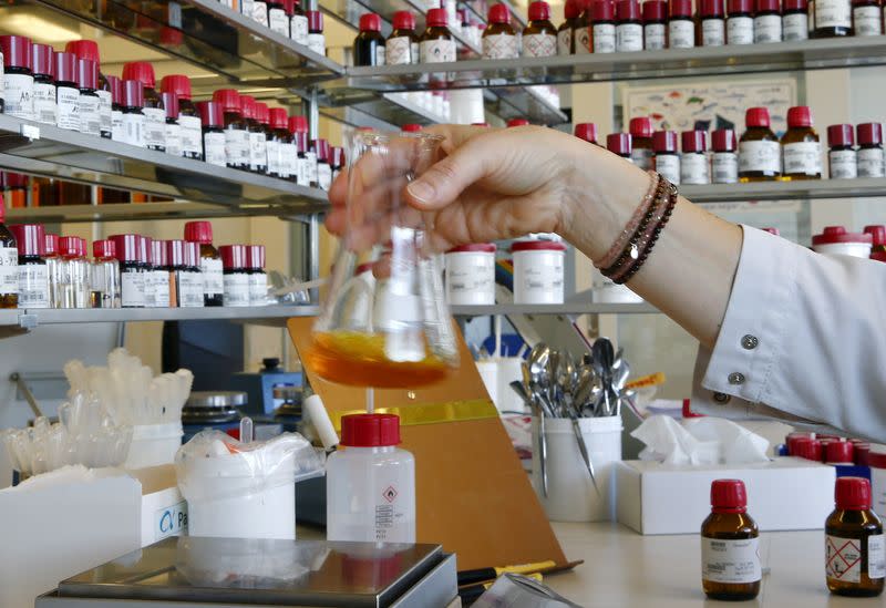 FILE PHOTO: An employee mixes liquid fragrances in a bottle in a laboratory of Swiss flavours and fragrances maker Givaudan in Duebendorf