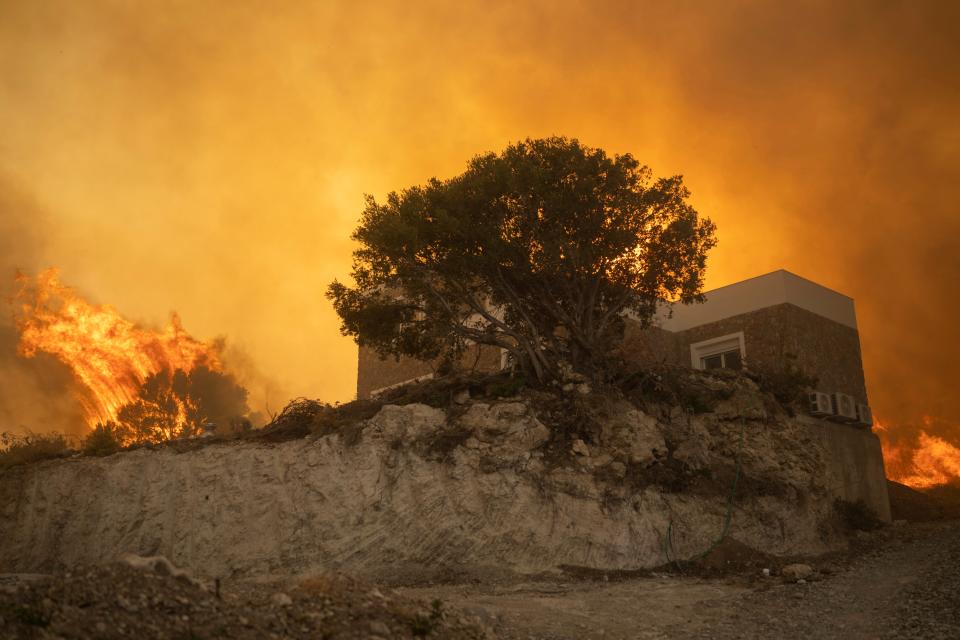 A wildfire burns in Gennadi village, on the Aegean Sea island of Rhodes, southeastern Greece, on Tuesday (AP)