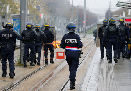 French police stand guard as youth and high school students burn a trash container during a protest against the French government's reform plan, in Bordeaux, France, December 6, 2018. REUTERS/Regis Duvignau