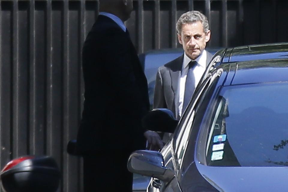 Former French President Nicolas Sarkozy (R) leaves his residence in Paris, July 2, 2014. Former French President Nicolas Sarkozy was placed under formal investigation on Wednesday on suspicions he tried to use his influence to thwart an investigation of his 2007 election campaign, the prosecutor's office said. REUTERS/Gonzalo Fuentes (FRANCE - Tags: POLITICS CRIME LAW)