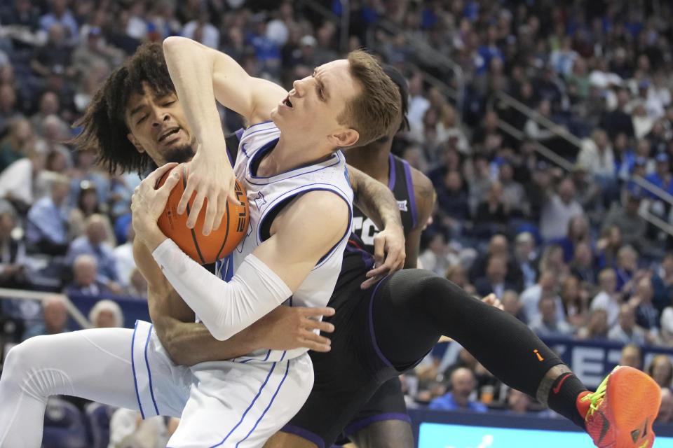 BYU guard Spencer Johnson, front, and TCU guard Micah Peavy, back, fight for a rebound during the first half of an NCAA college basketball game Saturday, March 2, 2024, in Provo, Utah. (AP Photo/George Frey)