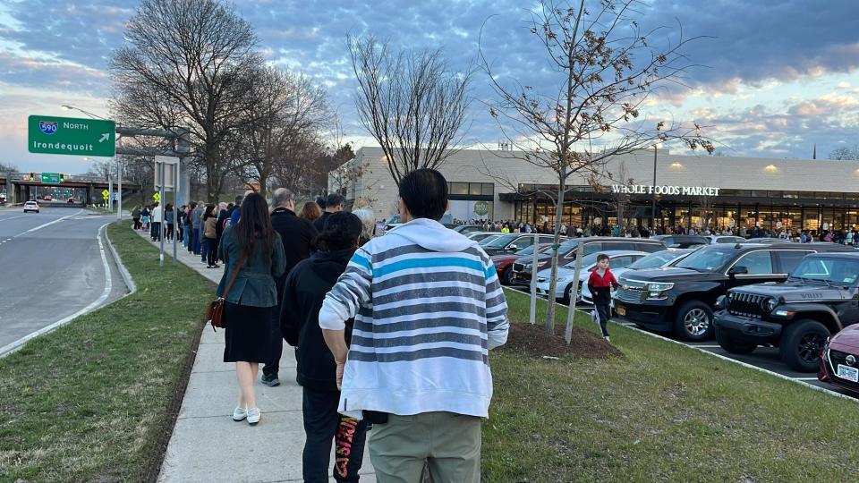 Shoppers wait in line at opening of Whole Foods in Brighton on Wednesday.