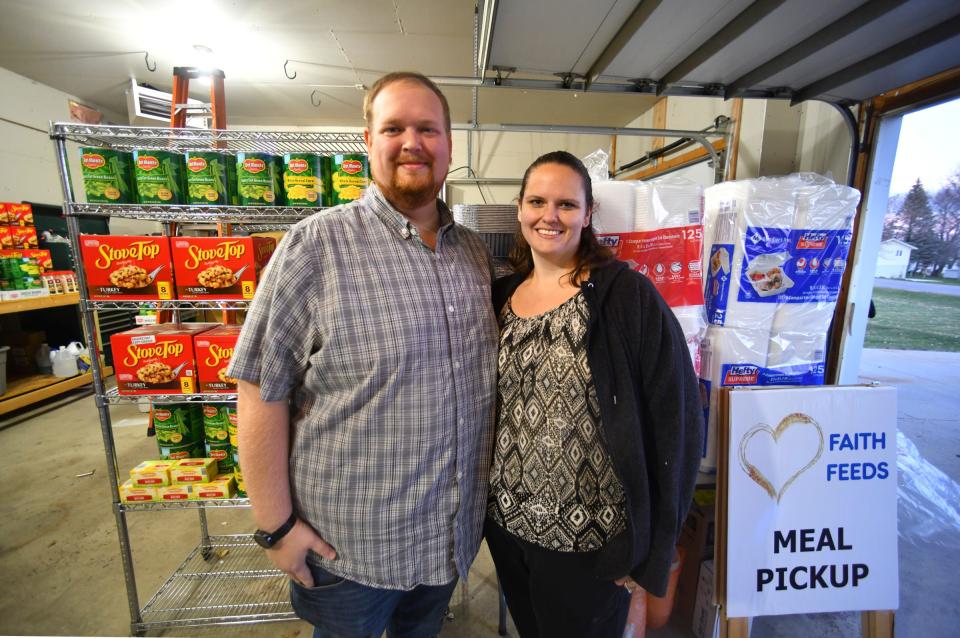 Liz and Ben Prigge stand next to some of the food and supplies they will use to prepare and distribute to area families in need for Thanksgiving Thursday, Nov. 18, 2021 at their home in St. Joseph.