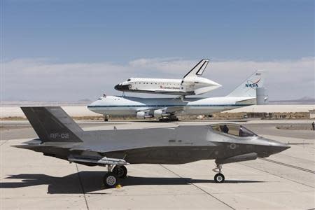 A Lockheed Martin F-35 Joint Strike Fighter (JSF) is pictured with the space shuttle Endeavour mounted atop its 747 Shuttle Carrier Aircraft (SCA) at the 461st Flight Test Squadron (FLTS) JSF Integrated Test Force at Edwards Air Force Base, California September 20, 2012. REUTERS/Paul Weatherman