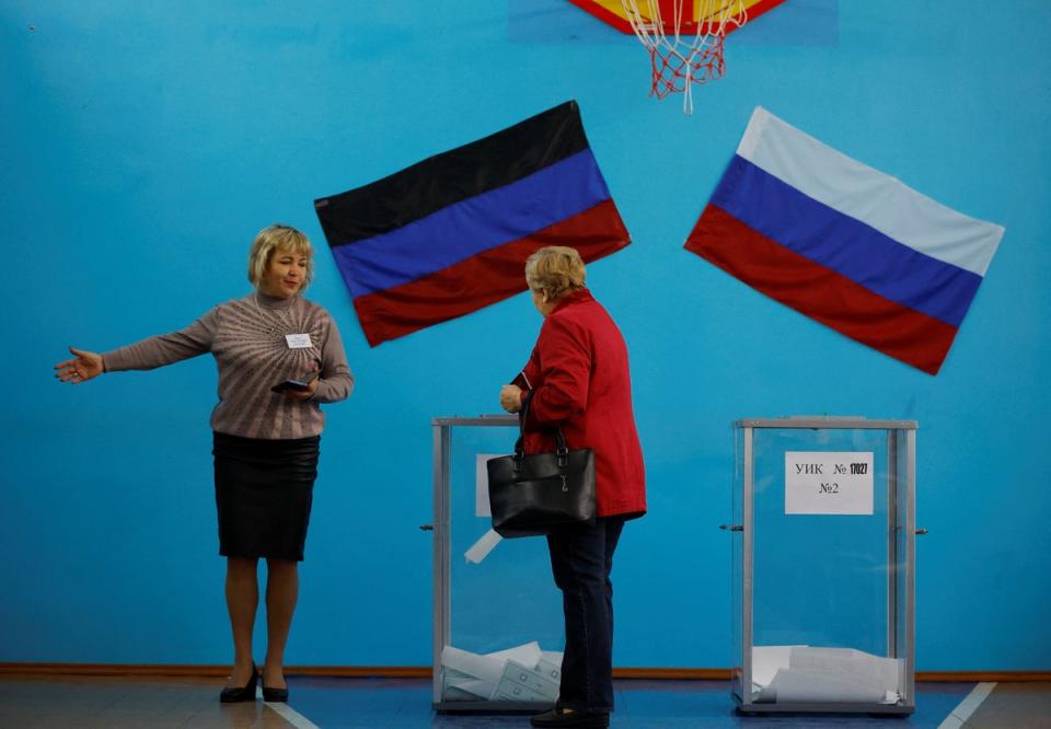 A member of an electoral commission shows the way to a voter at a polling station in Donetsk (Reuters)