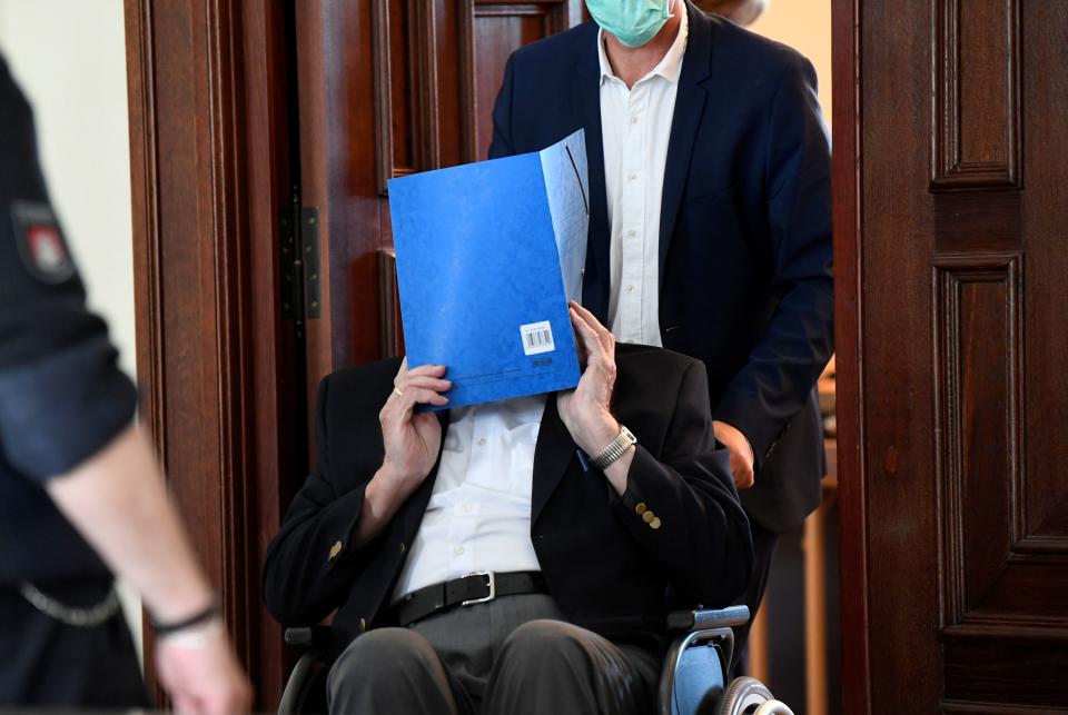 Bruno Dey, a former SS-watchman at the Stutthof concentration camp, hides his face behind a folder as he leaves the courtroom on a wheelchair after the verdict in his trial on July 23, 2020 in Hamburg, northern Germany. - The 93-year-old former Nazi concentration camp guard was handed a suspended sentence of two years in prison as a court in Hamburg found him guilty of complicity in WWII atrocities. In what could be one of the last such cases of surviving Nazi guards, Bruno Dey was convicted for his role in the killing of 5,230 people when he was a teenaged SS tower guard at the Stutthof camp near what was then Danzig, now Gdansk, in Poland. (Photo by FABIAN BIMMER / POOL / AFP) (Photo by FABIAN BIMMER/POOL/AFP via Getty Images)