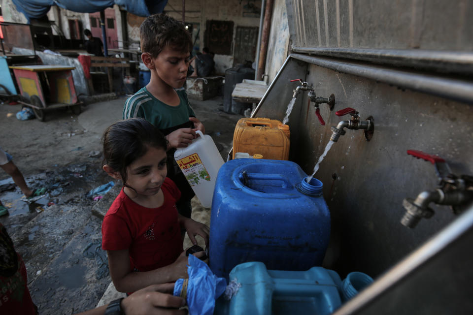 Palestinian children fill jerricans with drinking water from public taps during the Muslim holy month of Ramadan at the Rafah refugee camp, in the southern Gaza Strip, June 11.