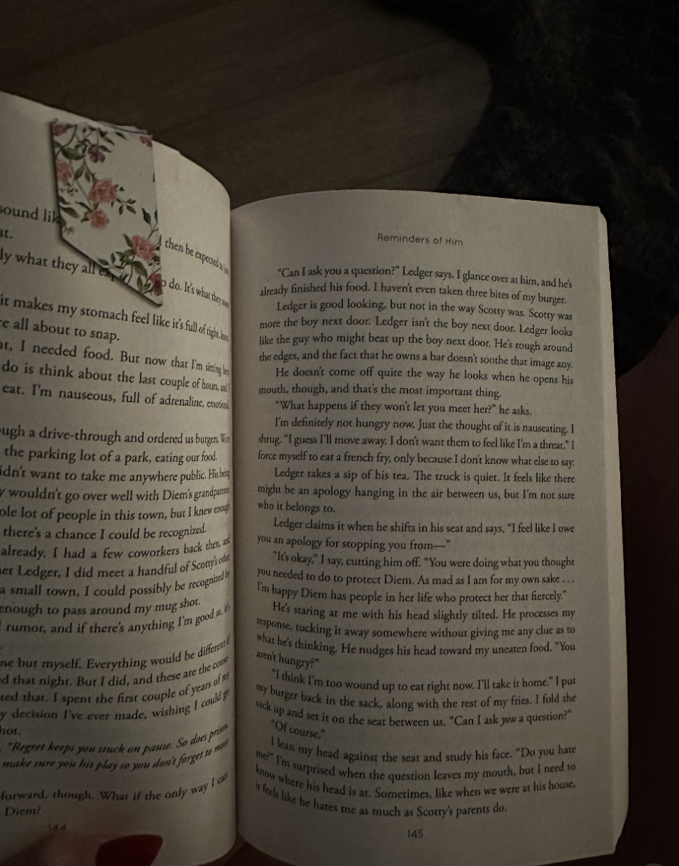 Open book with a floral bookmark, displaying two pages. The text on the pages consists of a story dialogue involving a character named Ledger