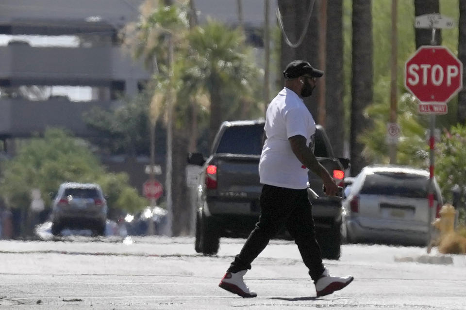 A pedestrian crosses a street as heat waves rise from the pavement as the temperature hits 104-degrees Monday, June 17, 2024, in Phoenix. Another excessive heat warning, caused by a heat dome, is expected in the Phoenix area on Thursday and Friday. (AP Photo/Ross D. Franklin)