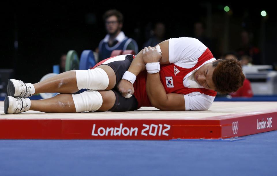 South Korea's Jaehyouk Sa lies injured on the men's 77Kg Group A weightlifting competition at the ExCel venue at the London 2012 Olympic Games August 1, 2012. REUTERS/Adrees Latif (BRITAIN - Tags: SPORT OLYMPICS SPORT WEIGHTLIFTING)