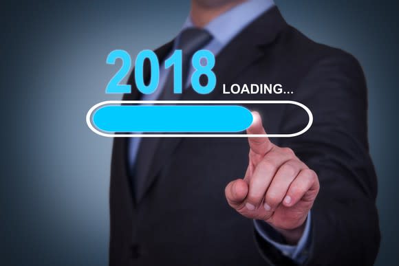 Businessman pointing to graphic showing 2018 and loading progress bar