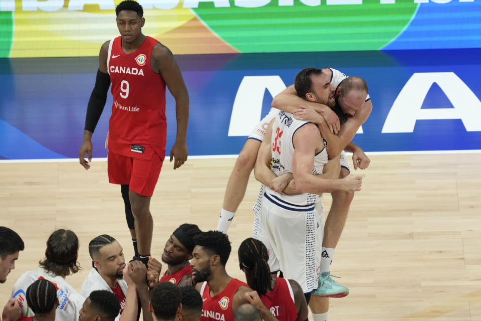 Serbia forward Dejan Davidovac, right, and Nikola Milutinov celebrate their win over Canada in a Basketball World Cup semi final game in Manila, Philippines, Friday, Sept. 8, 2023. (AP Photo/Aaron Favila)